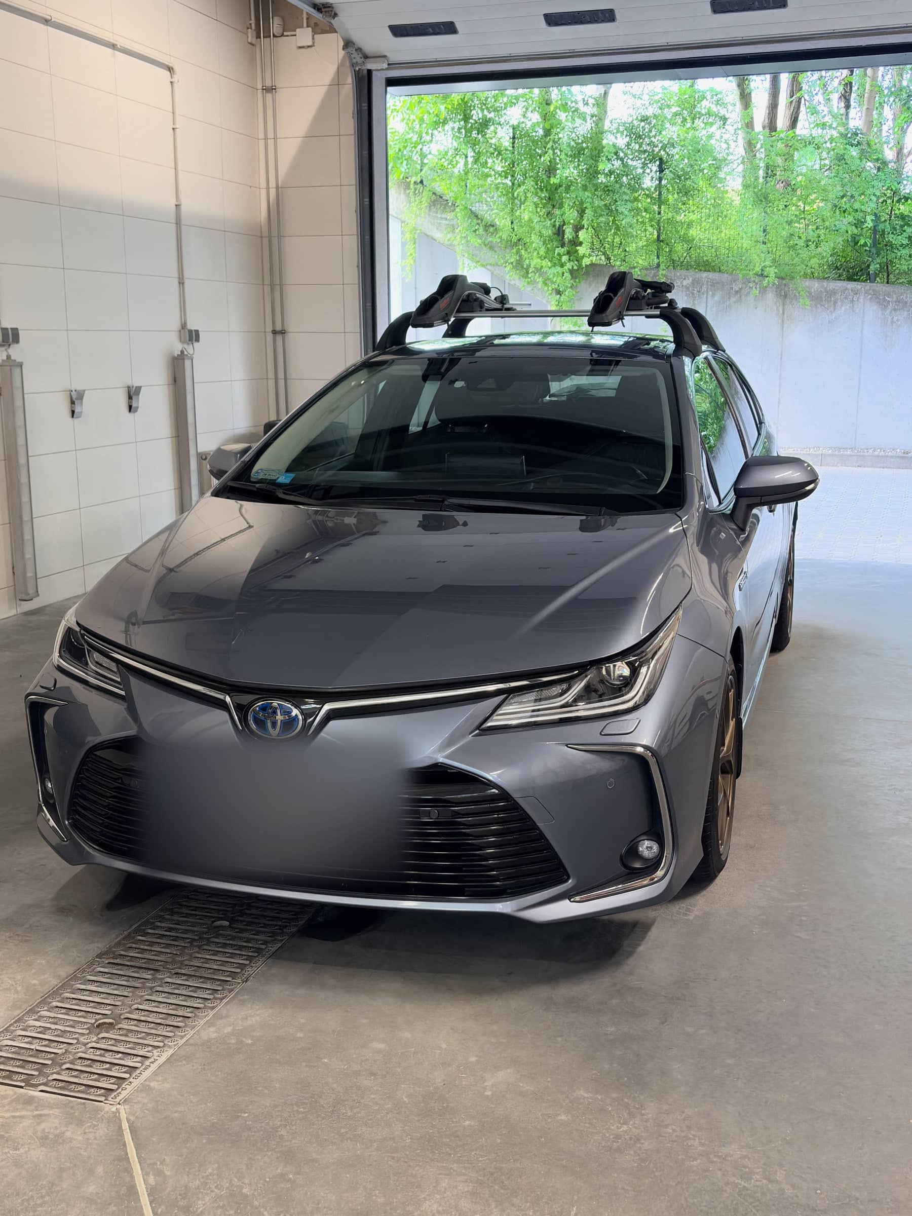 Szara Toyota Corolla po myciu w hali GO+ Car Spa, w tle otwarta brama