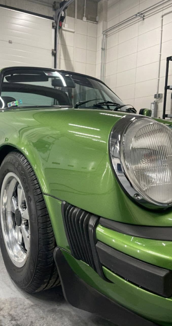 Zielony klasyczny Porsche 911 — błotnik, reflektor i felga z bliska