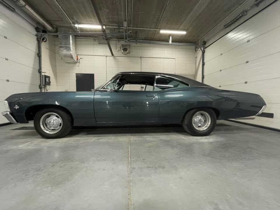 Ciemnozielony klasyczny Chevrolet Impala bokiem w hali GO+ Car Spa