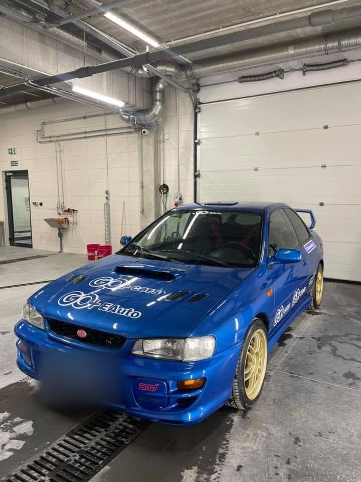 Niebieskie Subaru Impreza ze złotymi felgami i naklejkami GO+ cars oraz GO+ EAuto